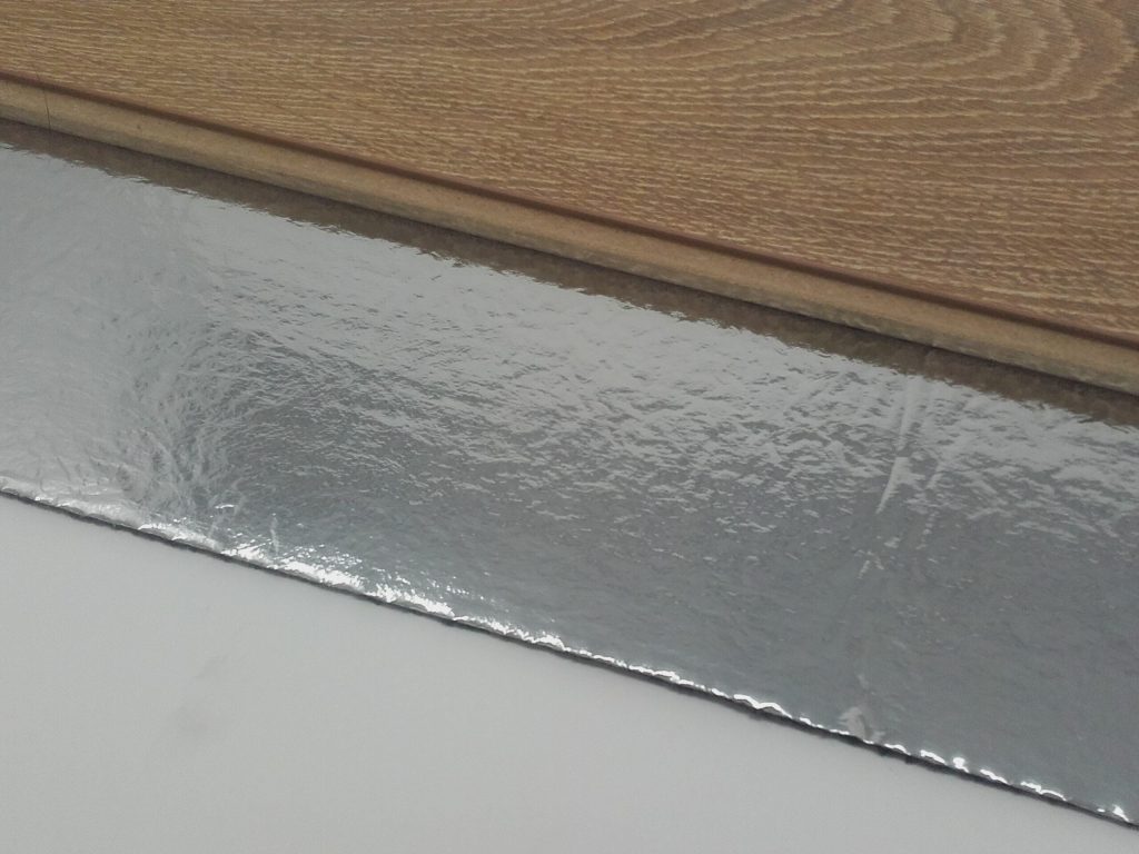 Laminaatplank op een rubberen 10 dB-ondervloer met aluminium dampscherm