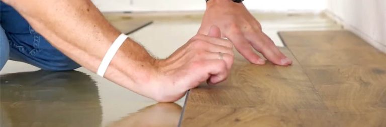 Vloerlegger legt een visgraat houten vloer op een pas aangebrachte ondervloer